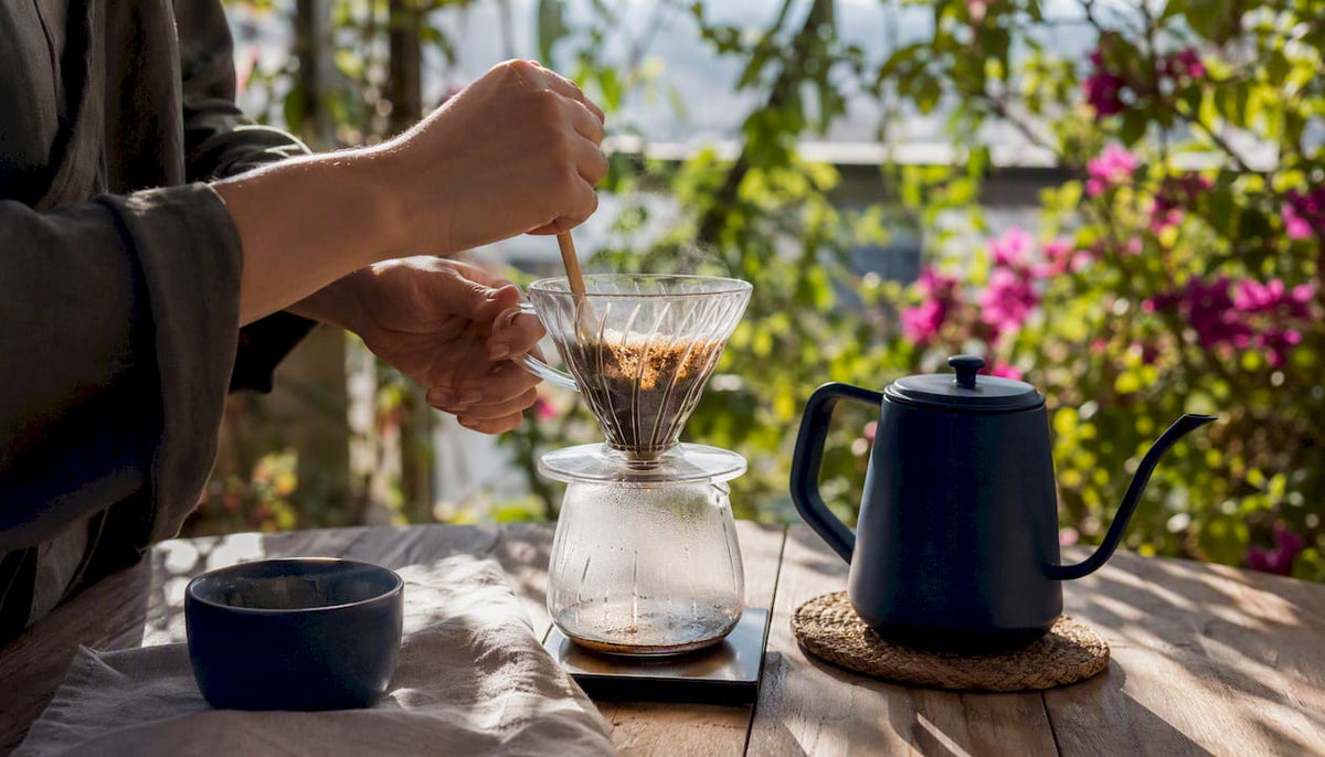 Hands pouring water over coffee grounds in pour-over