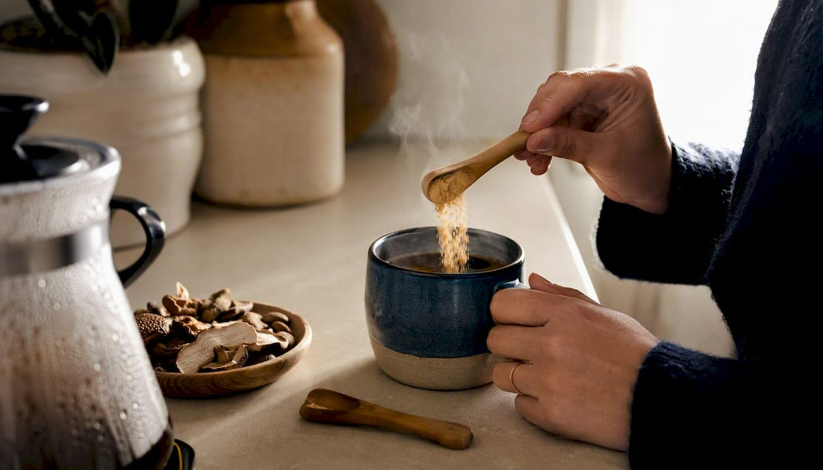 Hands pouring hot water over mushroom coffee