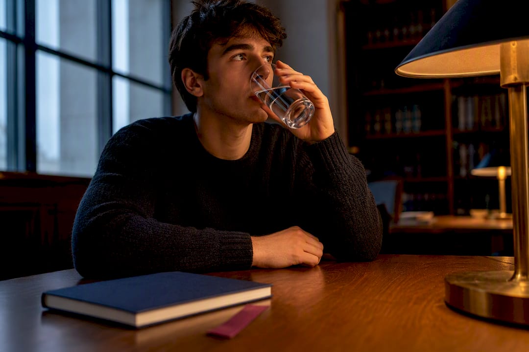 Student drinking water during study session